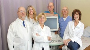 medical team in lab coats smiling at camera
