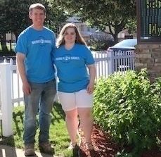 smiling couple facing camera and standing near Robbinsdale Women's Center sign